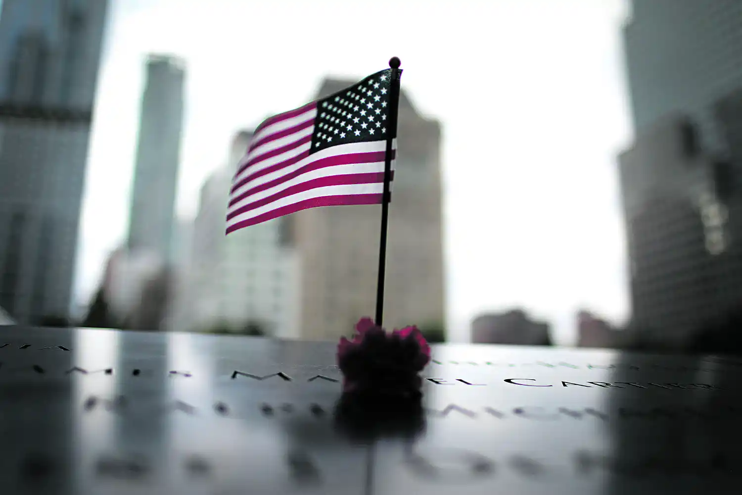 MIRANDO A LA CIUDAD. El borde sur del Memorial y Museo del 9/11 y parte de los edificios de Manhattan se reflejan en el agua de la fuente del monumento en el sitio donde cayeron las Torres.