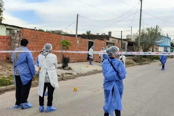 EN LA VEREDA. Los peritos del MPF buscan pruebas que ayuden en el inicio de la investigación del homicidio en Villa Mariano Moreno.
