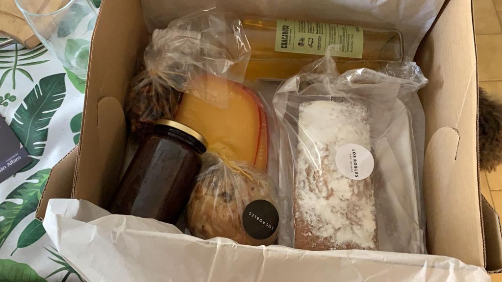 PRODUCTOS. La caja contiene productos como budín, muffins, vino y queso.