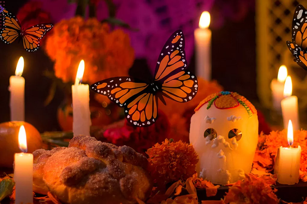 ALTAR MICHOACANO. Las ofrendas incluyen velas, flores, bebida, pan de muertos... y llegan las Monarca. 