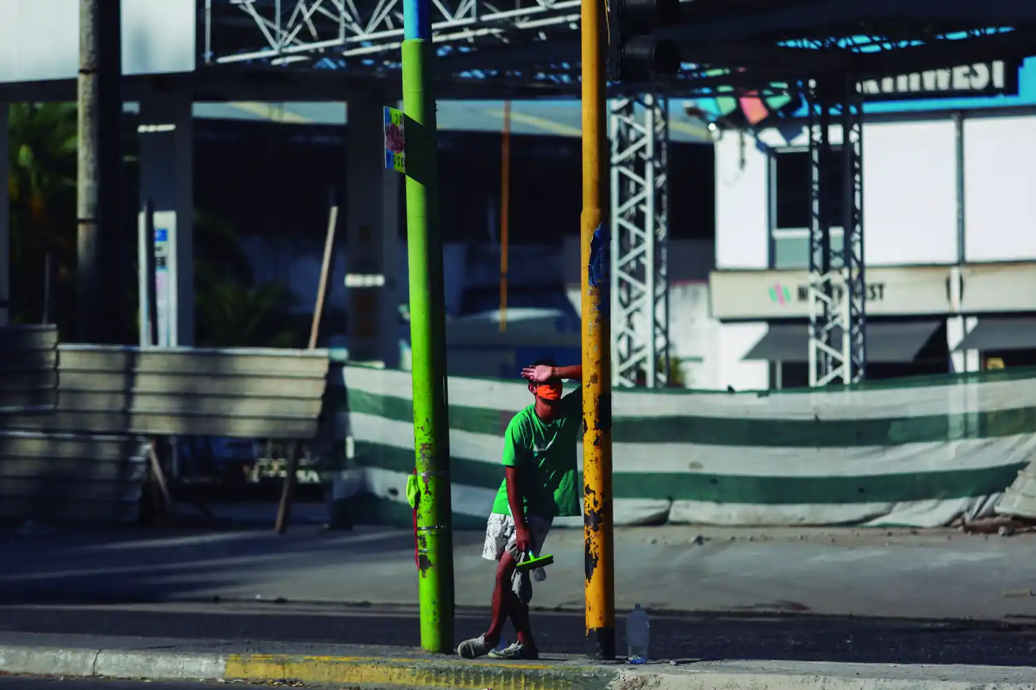 Un joven que trabaja como limpiavidrios aguarda en un semáforo frente al parque 9 de Julio, en San Miguel de Tucumán. Foto de Nicolás Núñez, gentileza aRGra
