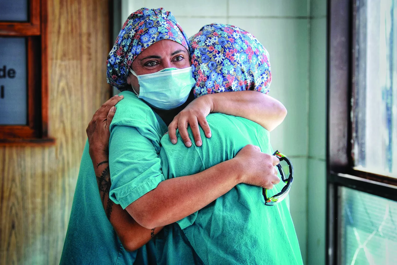 IMÁGENES DE LA MUESTRA. Las enfermeras Romina Quevedo y Florencia Rumi Macchi Zubiaurre se abrazan al recordar a los colegas fallecidos a causa del coronavirus. Foto de Hernán Foulliet, Gentileza de aRGra
