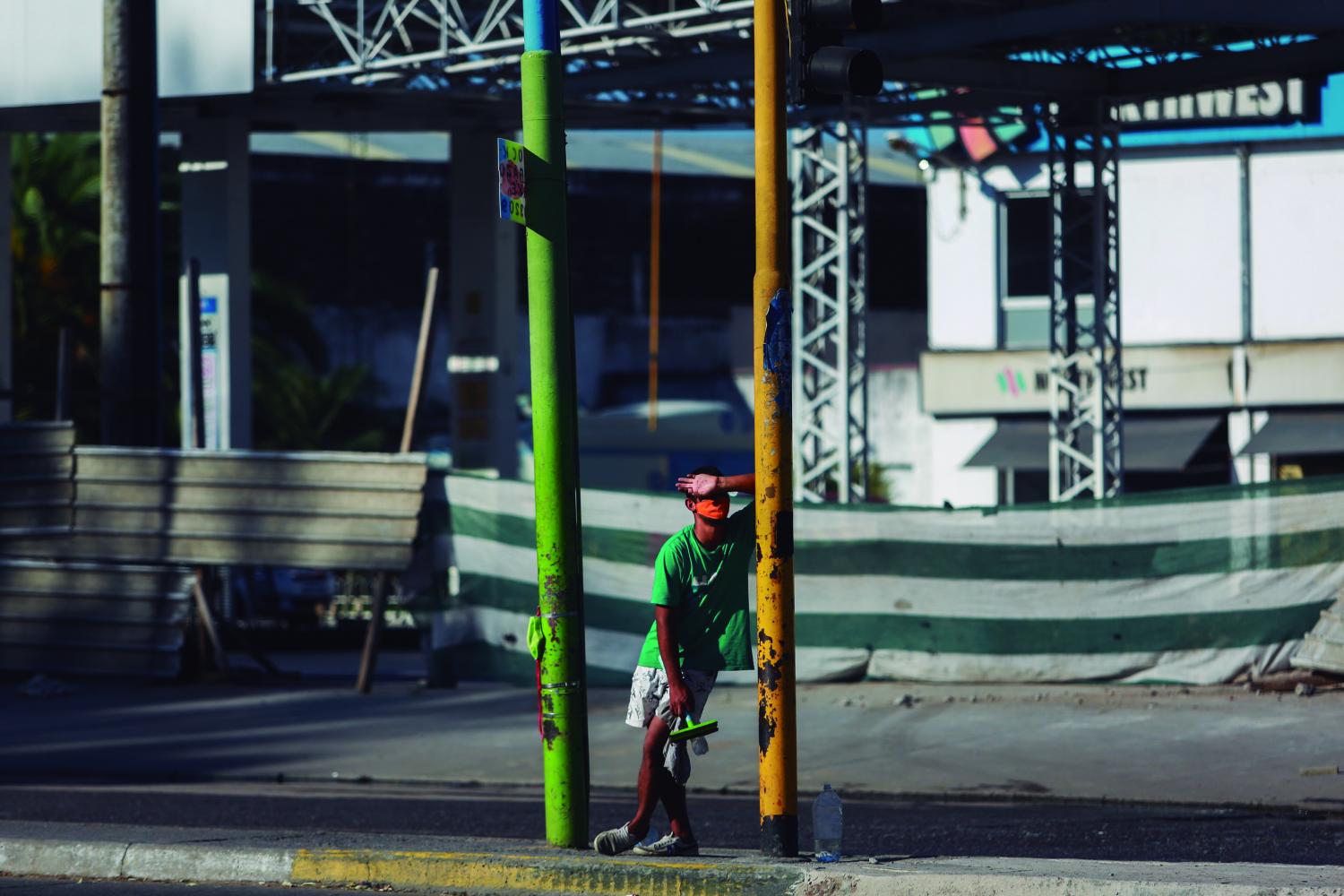 Un joven que trabaja como limpiavidrios aguarda en un semáforo frente al parque 9 de Julio, en San Miguel de Tucumán. Foto de Nicolás Núñez, gentileza aRGra