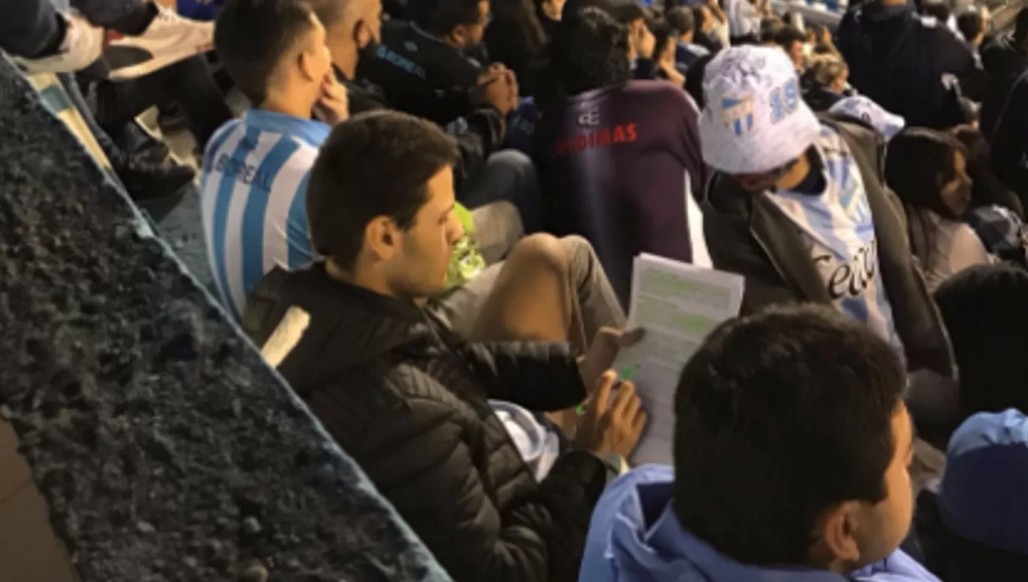 ESTUDIOSO. El simpatizante de Atlético no se quiso perder el juego ante Racing pero se llevó los textos para revisarlos en el entretiempo.