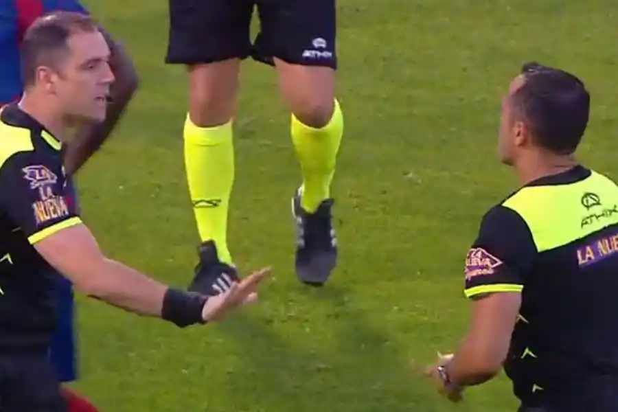 UN FRENO. Fernando Echenique, el cuarto árbitro, le pidió a Espinoza que se calme durante el partido en Liniers.