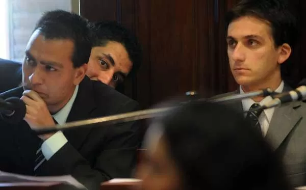 ESCONDIDO. Amín se oculta tras sus defensores Roberto Flores y Martín Zottoli durante una de las audiencias. 