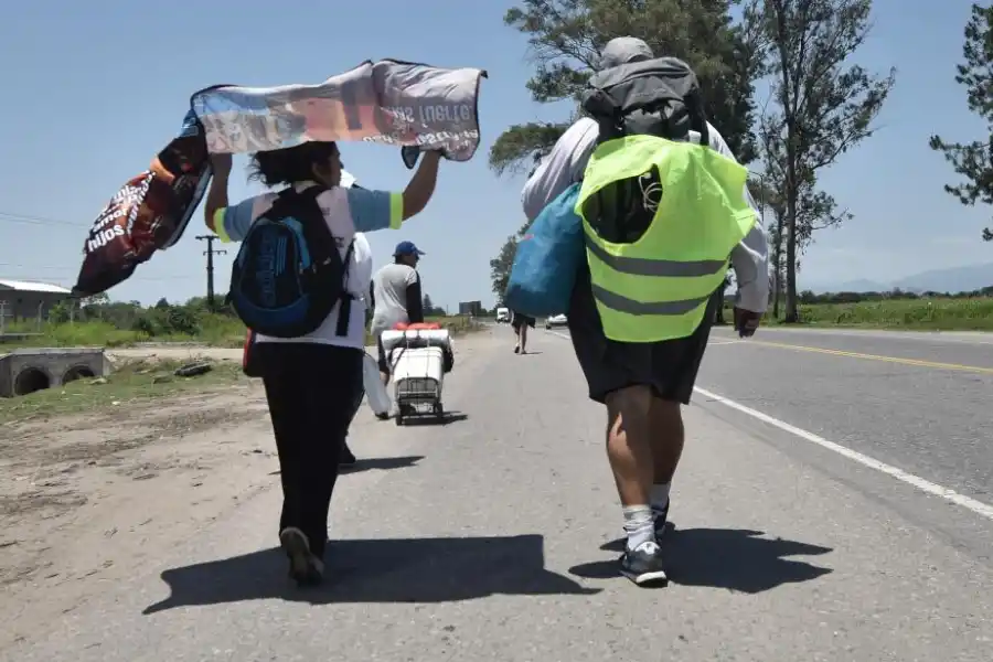 CARGADOS Y CON FE. Llevan mochilas con todo para acampar.