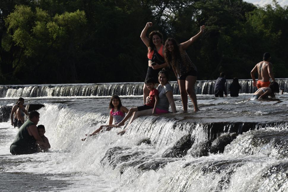 EN EL SUR. Una familia se refresca en una pequeña cascada en El Badén.