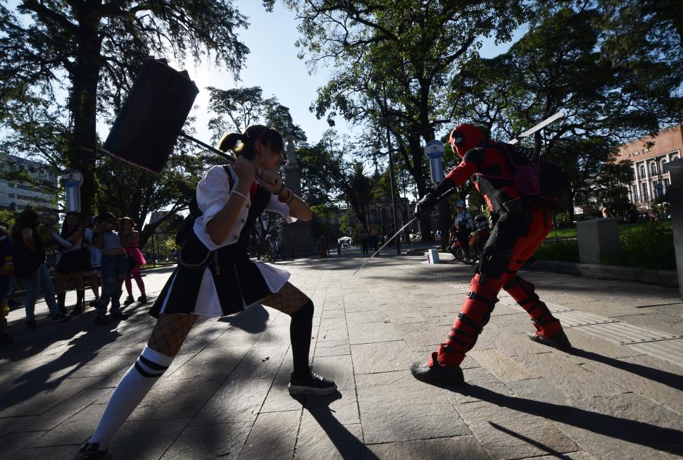 FUERZAS ANTAGÓNICAS QUE SE ENFRENTAN. Una persona con un disfraz inspirado en Monokuma de Danganronpa (con el martillo) en la plaza en medio de una batalla contra Deadpool. La idea de los organizadores también era que se diera este tipo de peculiares encuentros para entretenimiento de todos.  
