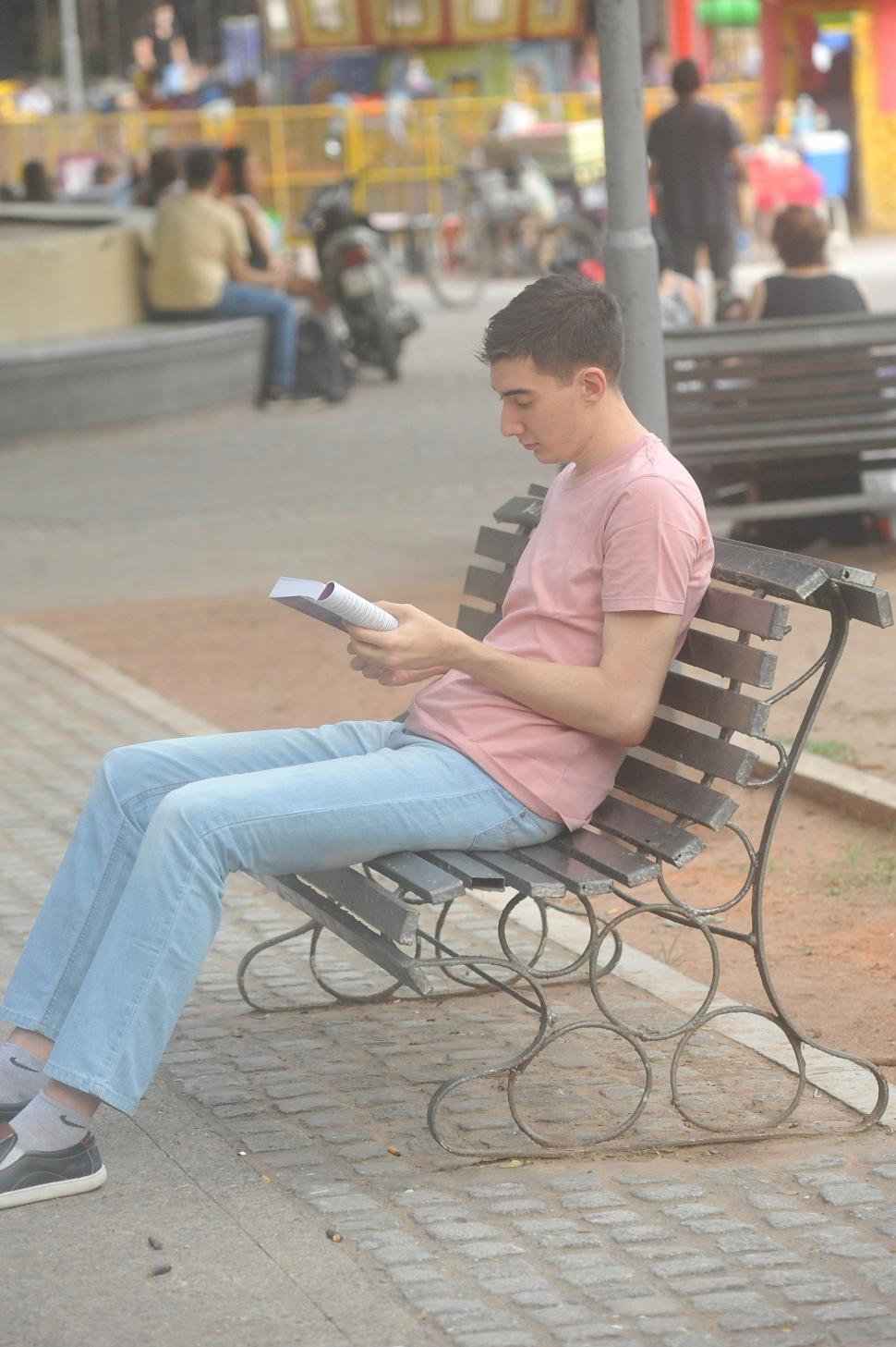 UN LECTOR. Un joven ocupó un banco de la Plaza Urquiza para enfrascarse en un libro, quizá la manera más inteligente de atravesar los rigores del calor.