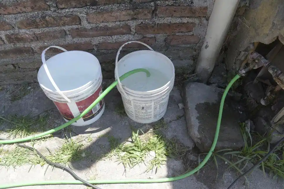 EN BALDES DE PLÁSTICO. En estos recipientes, los pobladores juntan agua para llevar a sus casas, un elemento que escasea en verano para sus pesares.  