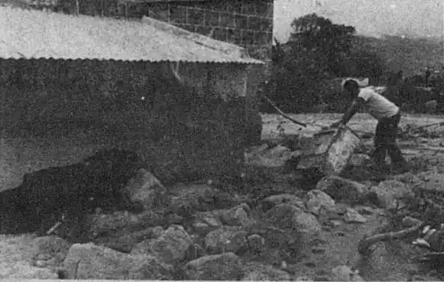 LIMPIEZA. Un vecino limpia el lodo que llegó y casi tapó su vivienda.