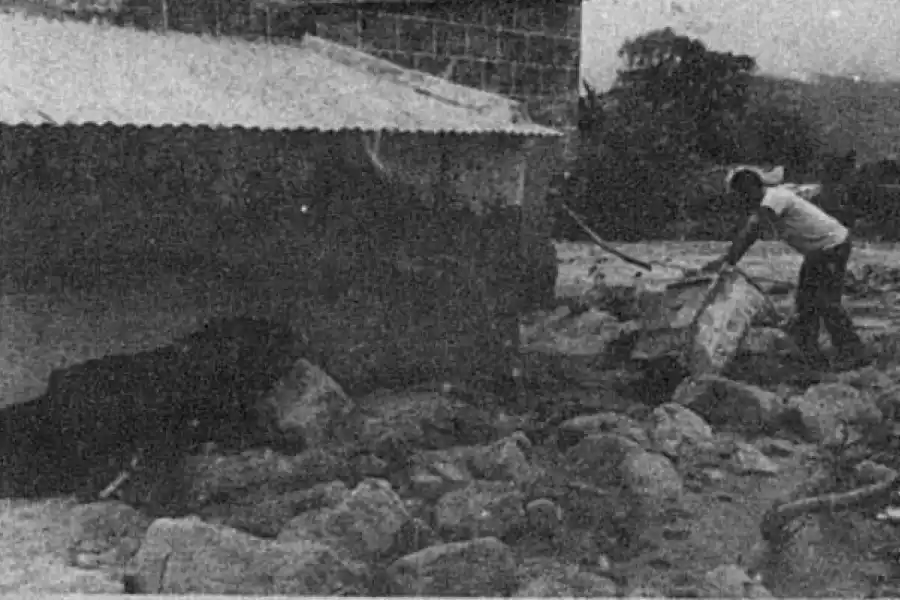 LIMPIEZA. Un vecino limpia el lodo que llegó y casi tapó su vivienda.