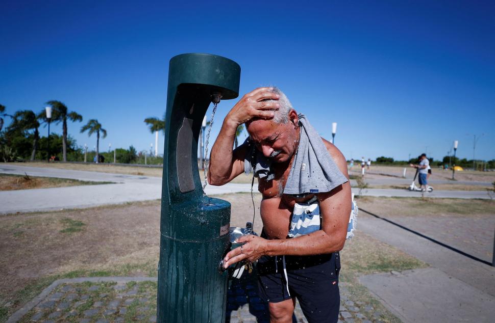 CALOR. Un hombre se hidrata en una plaza para combatir las altas temperaturas de las últimas semanas. reuters