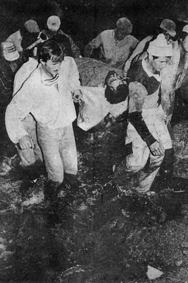 DURA TAREA. Los socorristas llevan en una rudimentaria camilla a uno de los ocupantes del helicóptero que se precipitó cuando evaluaba el daño originado por el aluvión de El Blanquito. 