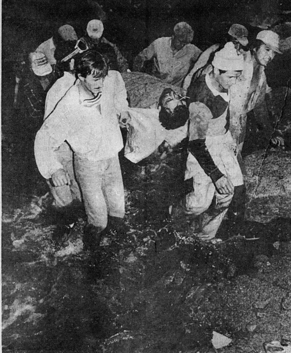 DURA TAREA. Los socorristas llevan en una rudimentaria camilla a uno de los ocupantes del helicóptero que se precipitó cuando evaluaba el daño originado por el aluvión de El Blanquito. 