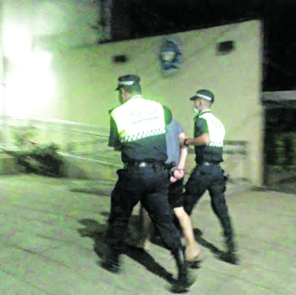 LA DETENCIÓN. Dos efectivos trasladan a la comisaría al acusado luego del arresto. Foto aportada por el ministerio de Seguridad.   