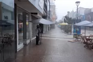 La imagen viral del mozo que espera que pare la tormenta para volver a recibir clientes