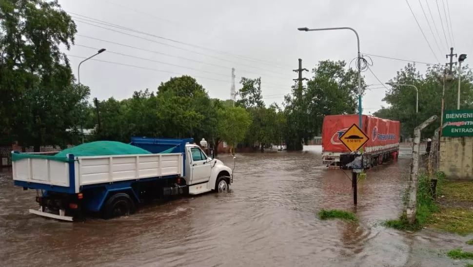 IMPARABLES. Los camiones avanzan lentamente por las calles inundadas. Varios choferes de vehículos más chicos se refugiaron sobre las veredas.
