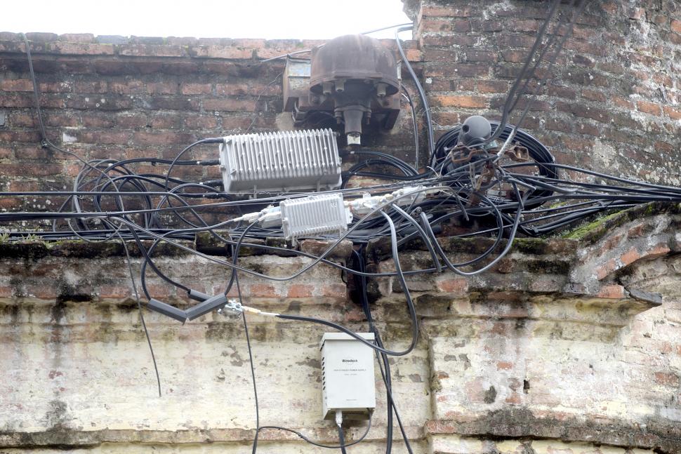COMO UN NUDO GORDIANO. Una sucesión por momentos anárquica de cables y conexiones se enredan en la parte superior de una casa. Entre rollos y cajas se torna imposible diferenciar las líneas o el sentido que siguen o las tomas donde se conectan o, siquiera, el extremo de algunas líneas.