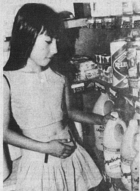 BIEN DE PRIMERA NECESIDAD. Una niña busca en una góndola un recipiente con lavandina en una despensa.