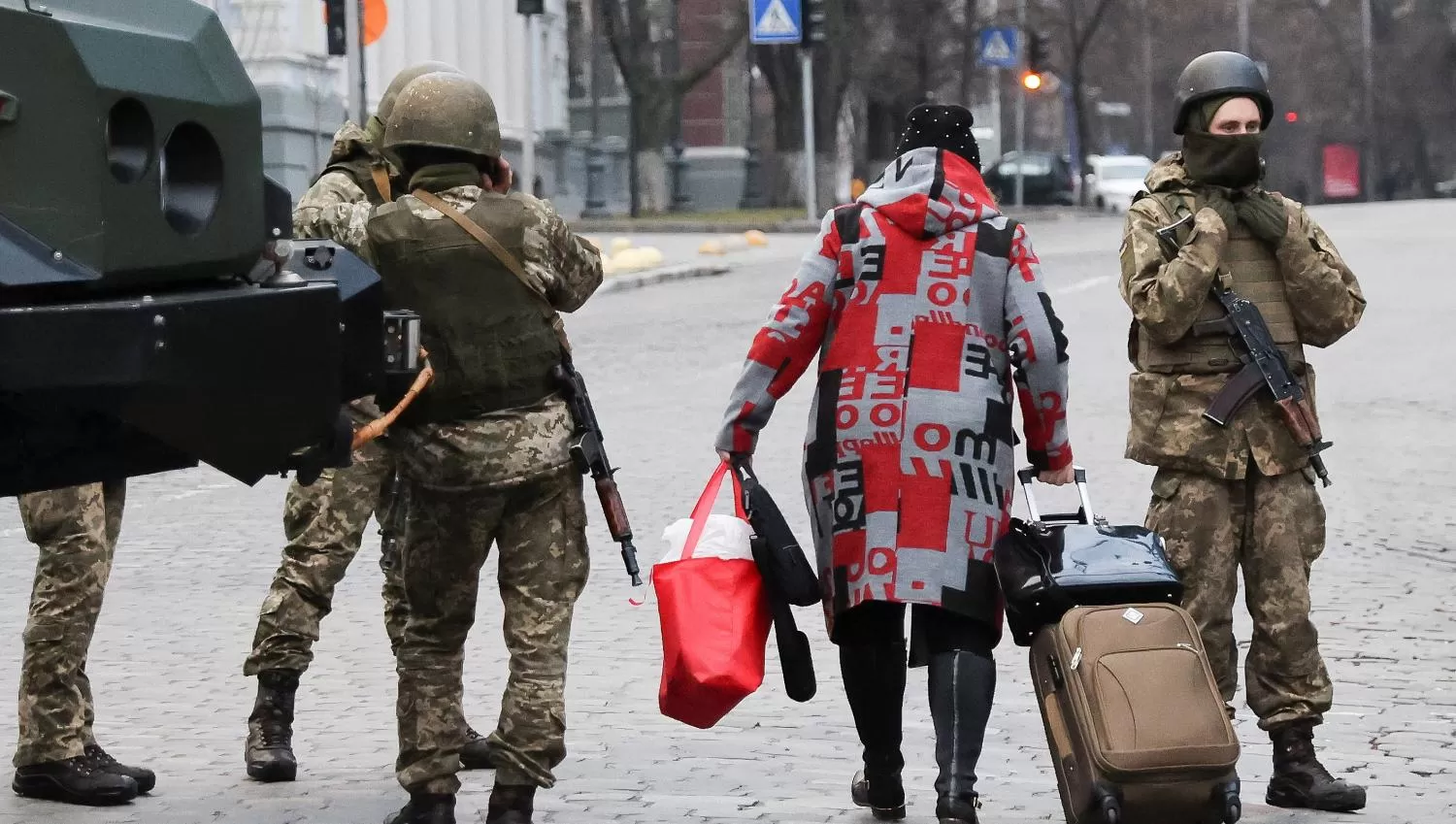 CON LO PUESTO. Una mujer salió a la calle con una cartera, un bolso y una valija en busca de un refugio ante el ataque ruso.