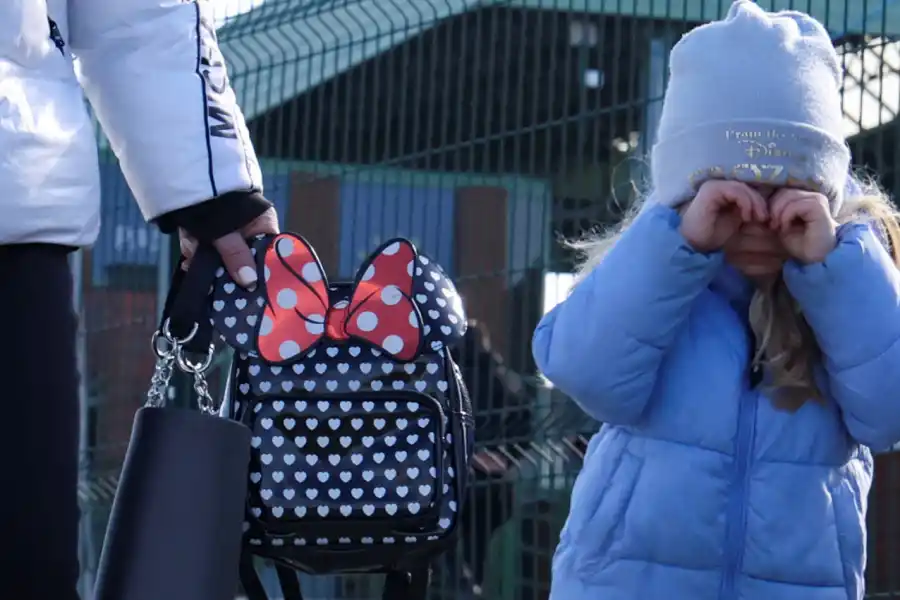 A POLONIA. Una niña junto a su madre caminan hacia el puesto fronterizo de Medyka, en Polonia.