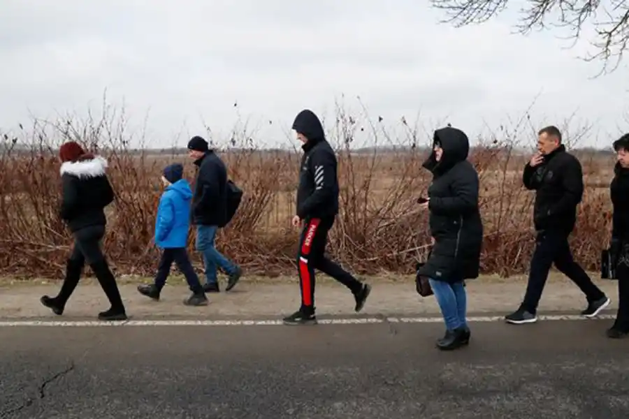 HACIA EL SUR. Ucranianos caminan por el puesto fronterizo húngaro de Beregsurany.