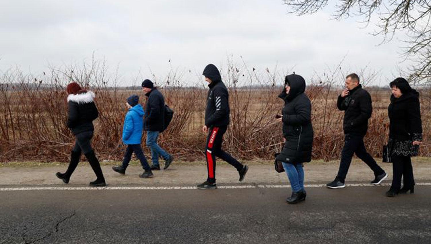 HACIA EL SUR. Ucranianos caminan por el puesto fronterizo húngaro de Beregsurany.