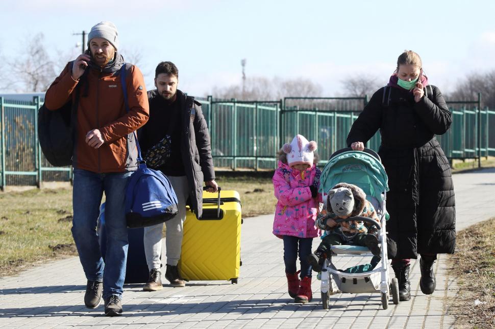 EN EL LÍMITE. Personas y niños caminan en el cruce fronterizo entre Polonia y Ucrania, después de que el presidente ruso, Vladimir Putin, autorizara una operación militar en el este de Ucrania, en Medyka, Polonia.