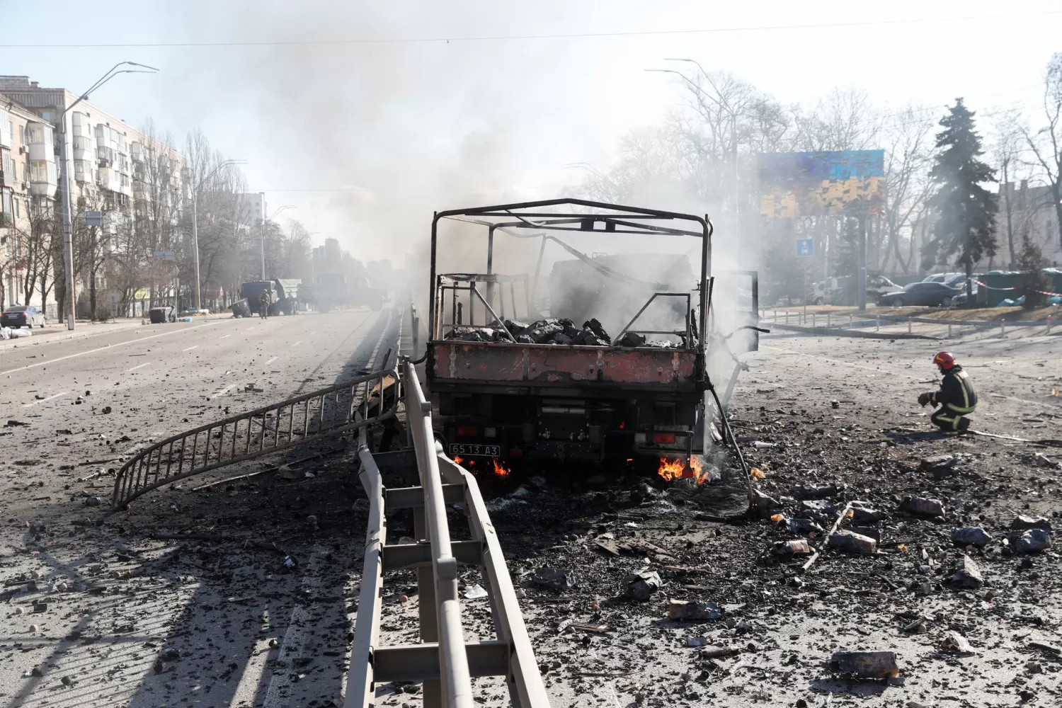 ESCENARIO BÉLICO. Un bombero ucraniano se arrodilla junto a un vehículo dañado, en el lugar de un combate con las tropas rusas en Kiev. REUTERS/Valentyn Ogirenko