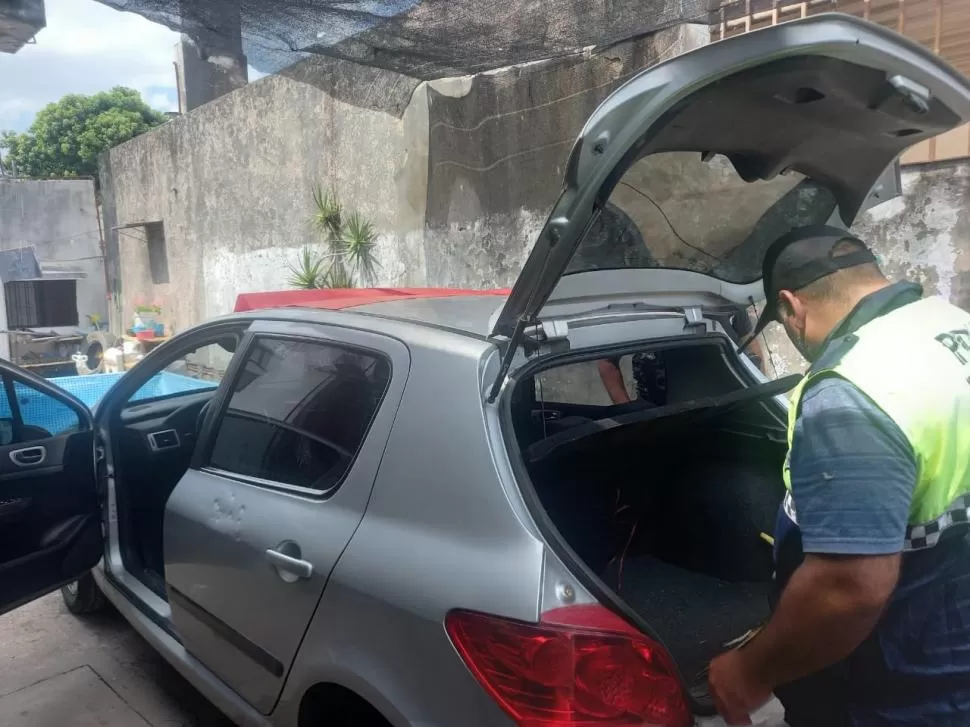 OBJETIVO CUMPLIDO. Un policía revisa el auto que habrían utilizado los sospechosos para cometer ilícitos. 