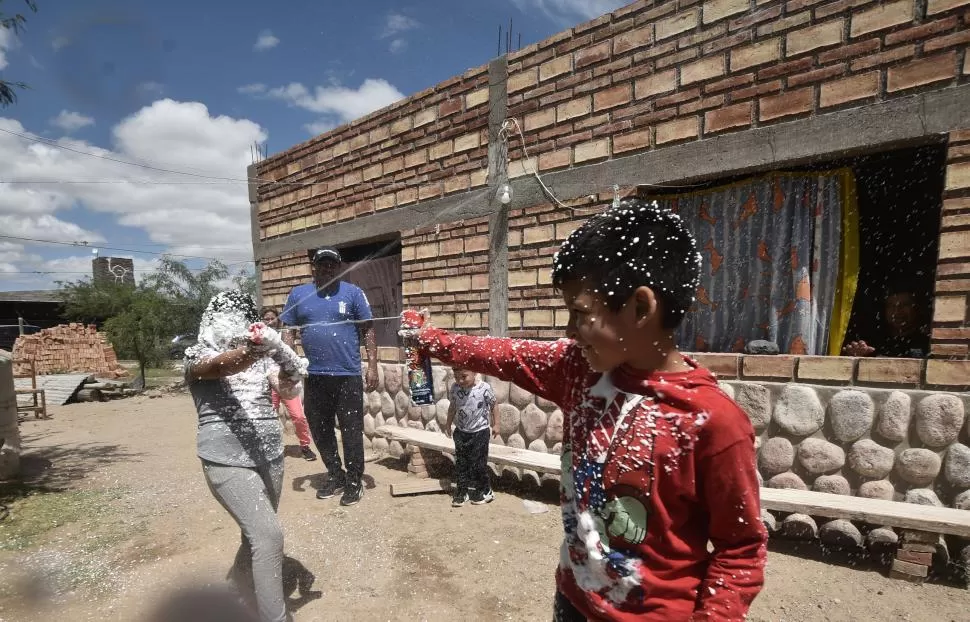 CARNAVAL. Los chicos de Amaicha del Valle jugando en familia con espuma en el patio de sus casas.