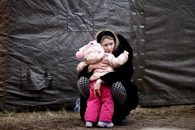 VICTIMAS DE LA GUERRA. Una mujer que huye de la invasión rusa de Ucrania abraza a un niño en un campamento temporal en Przemysl, Polonia. REUTERS
