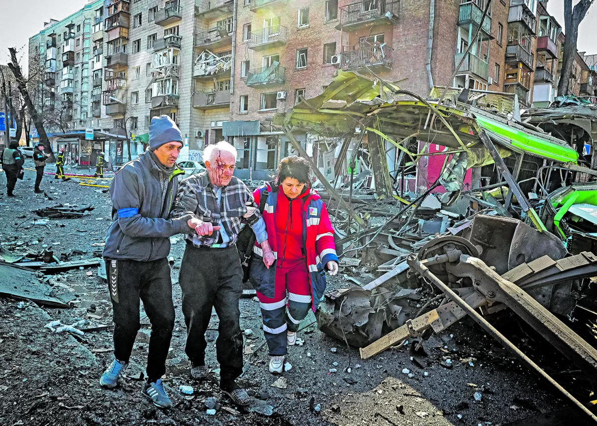 CONTRA LA POBLACIÓN. Caminando entre los escombros, y con la ayuda de vecinos, voluntarios y personal médico, los residentes son evacuados entre los restos de un barrio destruido por las bombas, en la capital ucraniana. 