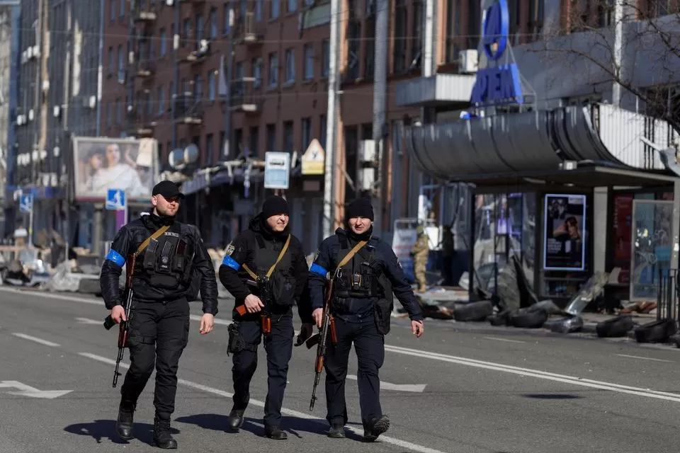 Oficiales de policía armados patrullan después de unos bombardeos rusos en Ucrania. Foto de Reuters