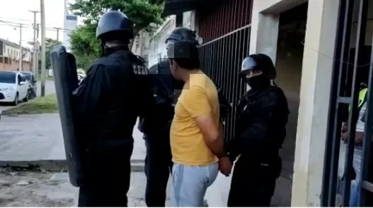 TRAS LAS REJAS. Hombres del grupo de elite de la Policía trasladan al sospechoso Juan José Símula el día que lo detuvieron en su domicilio. 