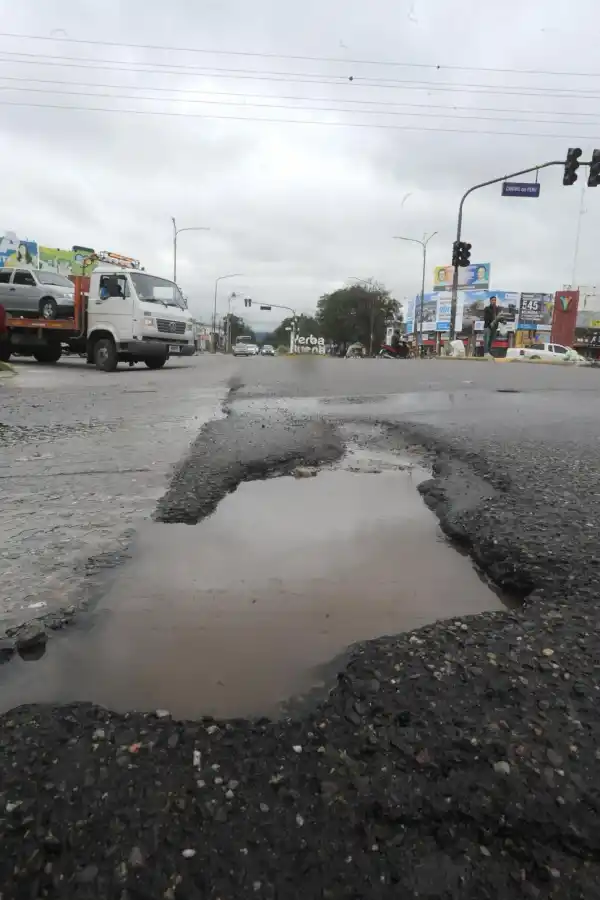 TRAMPA EN EL CRISTO. Apenas los conductores ingresan a la Mate de Luna desde Yerba Buena, un gran bache lleno de agua los sorprende. La avenida había sido repavimentada hace meses.  LA GACETA / FOTOS DE ANTONIO FERRONI