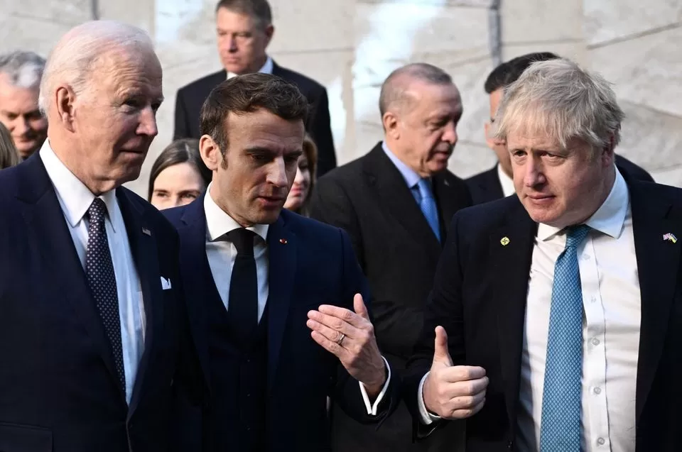 El primer ministro británico, Boris Johnson, el presidente francés, Emmanuel Macron, y el presidente estadounidense, Joe Biden, hablan al llegar a la sede de la OTAN en Bruselas. Reuters.