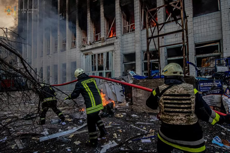  PROTAGONISTAS. Los bomberos luchan contra el fuego y la destrucción sembrados por las bombas rusas en Ucrania. Abajo: Putin, Zelenski y la cuestionada Brigada Azov.