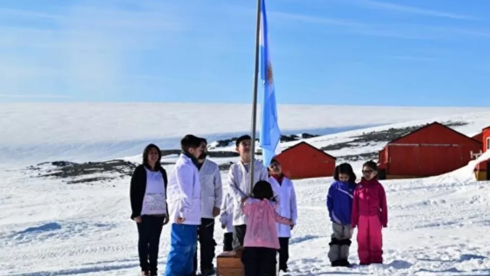 IZAMIENTO. Los alumnos de la única escuela de la Antártida suben la bandera.