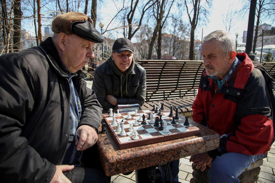 Dos hombres juegan al ajedrez en un parque, en medio de la invasión rusa de Ucrania, en Kiev. Foto de Reuters