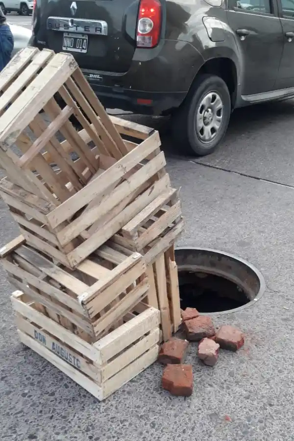 ¡Un peligro! Una pila de cajones sobre un pozo advierte a los conductores