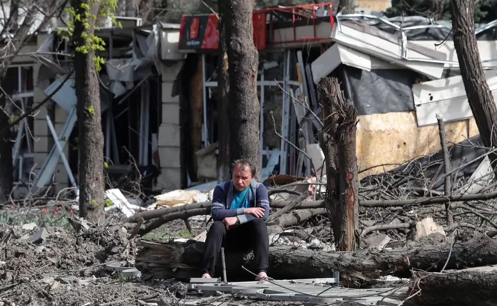 SOLEDAD. Junto a una casa en ruinas, un vecino de Mariúpol hace una pausa en la tarea de sacar escombros.