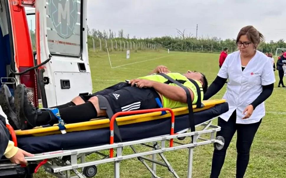 MOMENTO DE TENSIÓN. El árbitro Oscar Pérez es trasladado en una ambulancia después de haber sido herido.  