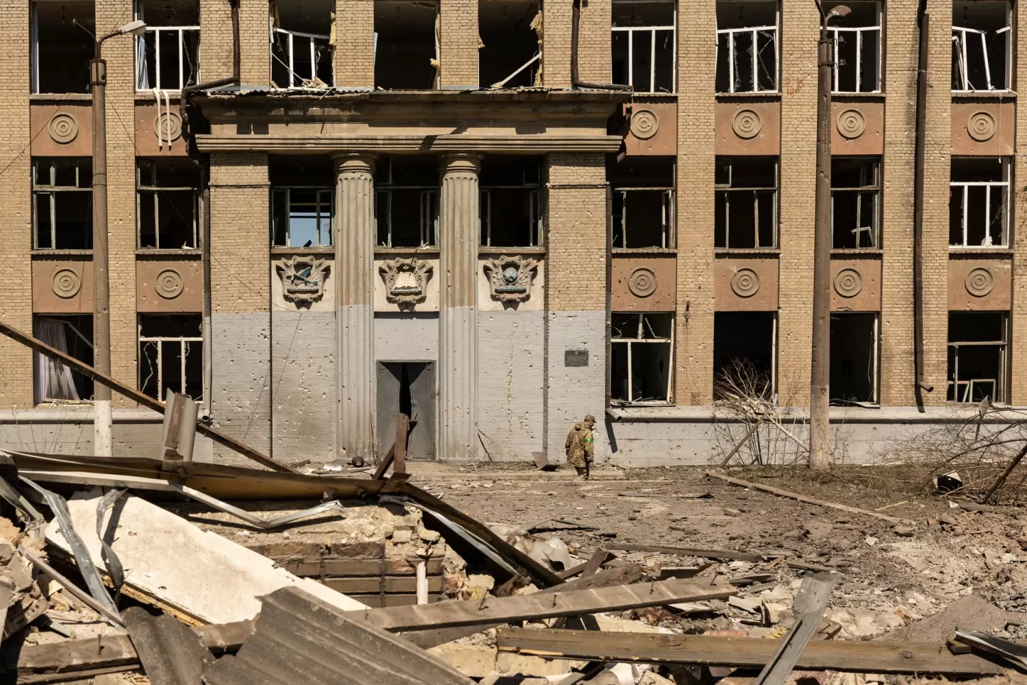 Un soldado ucraniano camina frente a una escuela que fue bombardeada durante la invasión de Rusia en Ucrania, en Kostyantynivka, en la región de Donetsk, Ucrania, el 8 de mayo de 2022.