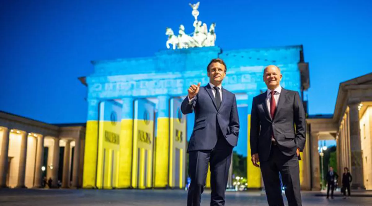 BERLÍN. El presidente de Francia y el canciller alemán, frente a la Puerta de Brandenburgo, iluminada con los colores de la bandera de Ucrania. 