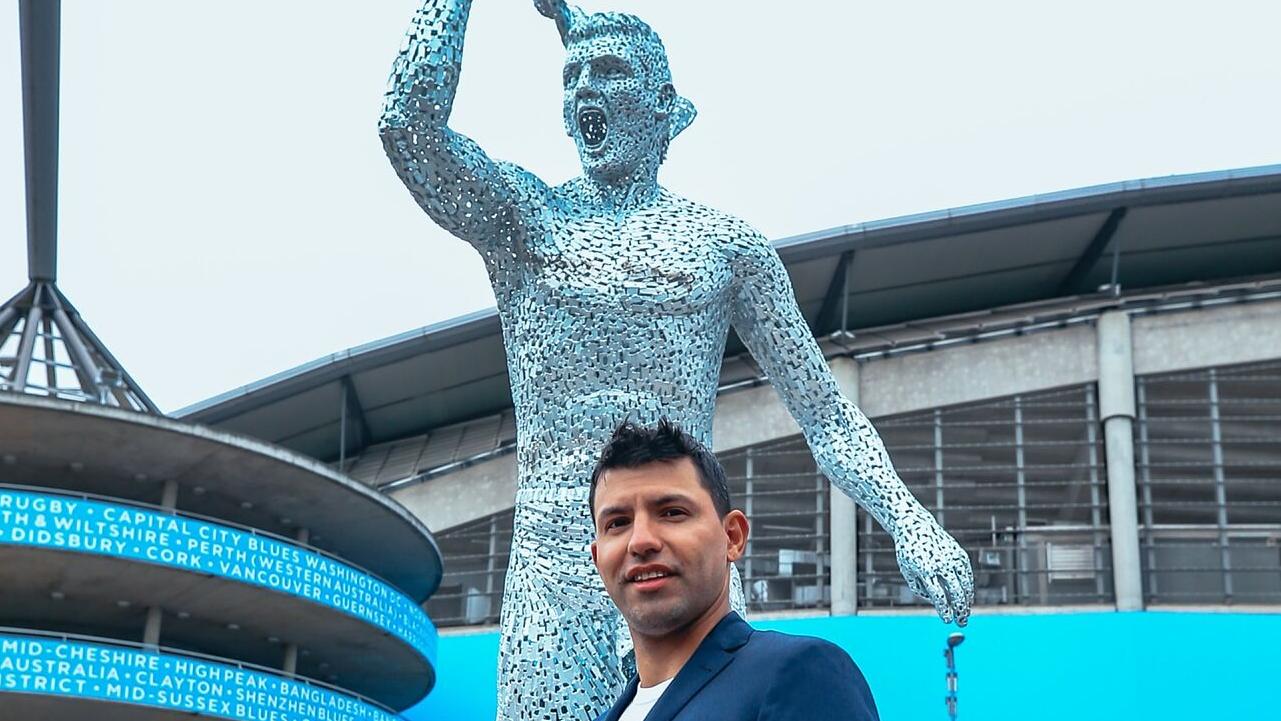 Sergio Agüero junto a su estatua en el Manchester City