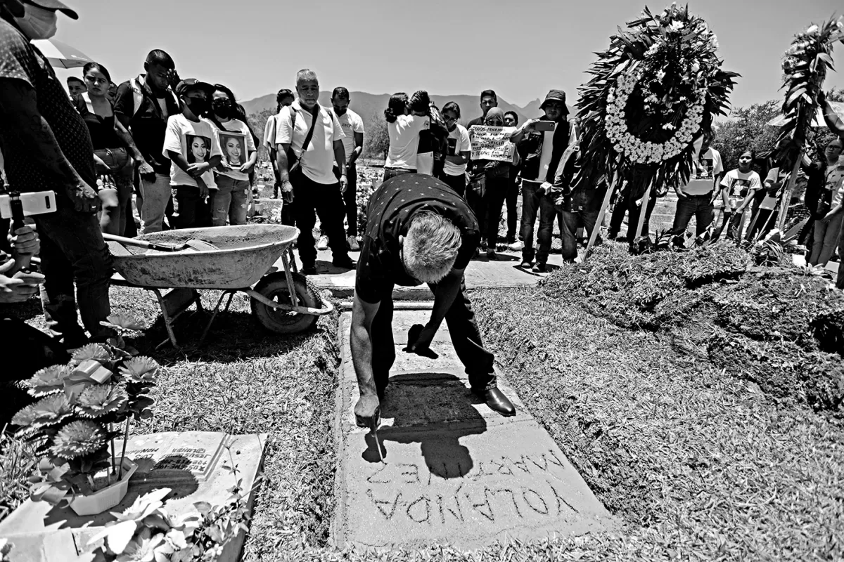 NOMBRE. Gerardo Martínez talla la lápida de su hija, sobre la tumba de la joven asesinada en Nuevo León.