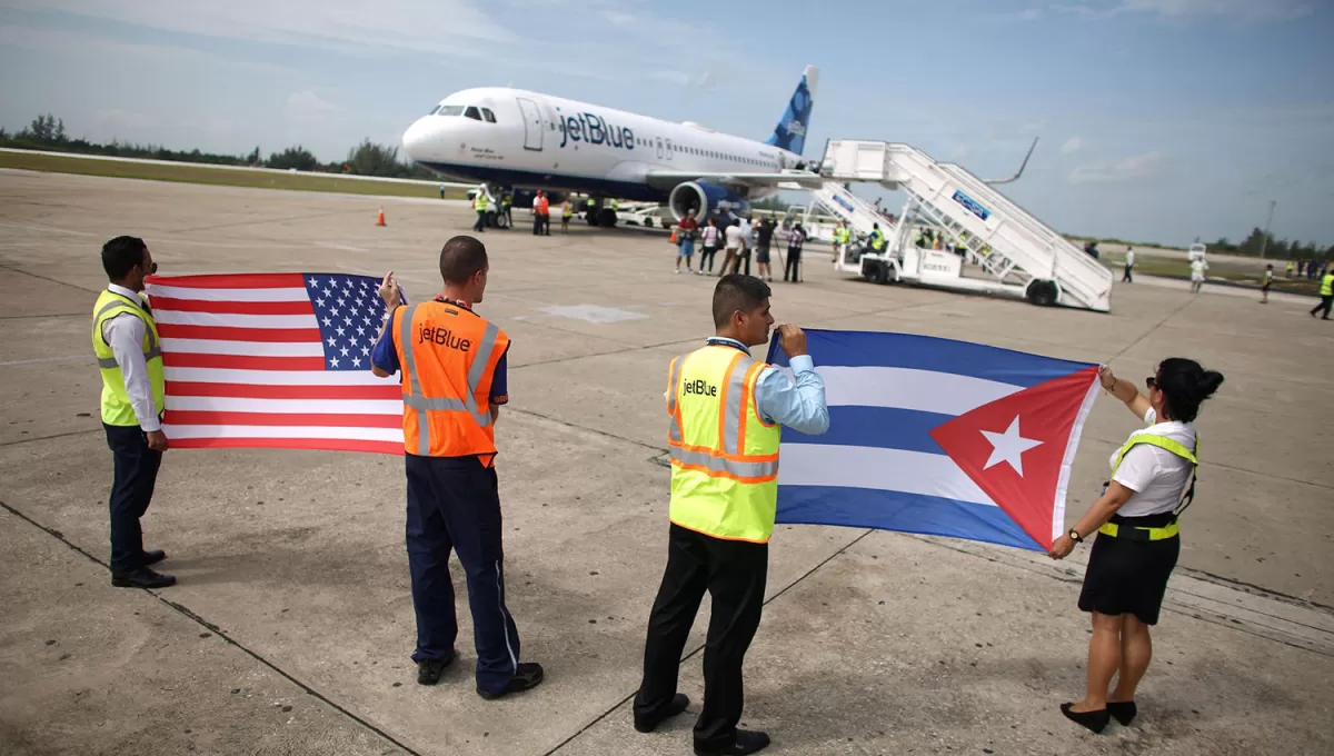 BIENVENIDA. Empleados de una aerolíneas reciben con las banderas de Estados Unidos y de Cuba al primer vuelo comercial que llegó hasta Santa Clara, en tierras cubanas.